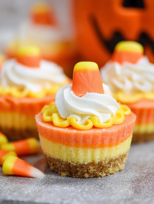 Three mini cheesecakes with candy corn toppings.