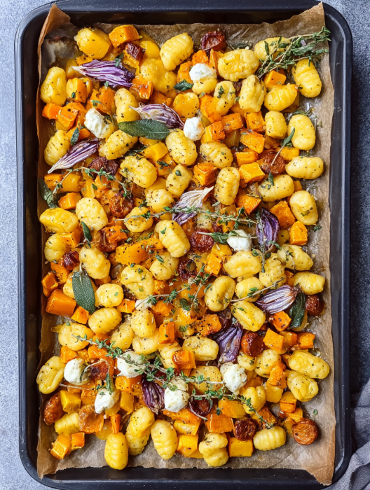 A pan of food with cheese, onions, and garlic.