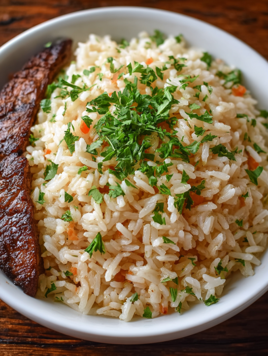 A bowl of rice with a piece of meat on top.