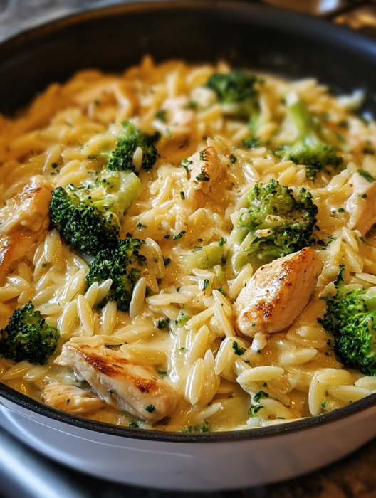 A bowl of pasta with broccoli and chicken.