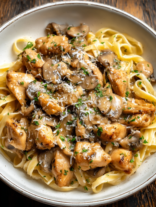 A plate of food with chicken, mushrooms, and noodles.