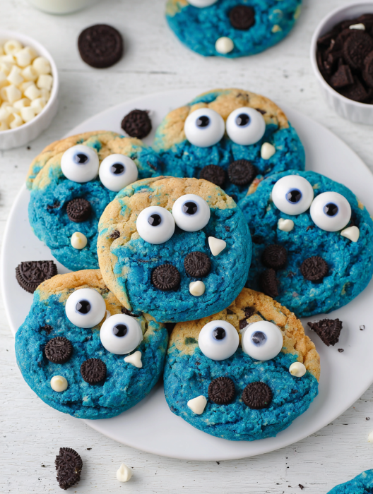 A plate of blue cookies with white eyes and chocolate chips.