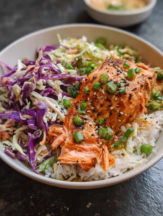 A bowl of food with salmon and rice.