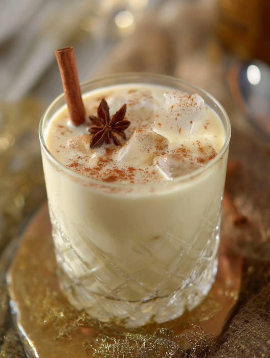 A glass of milk with a cinnamon stick in it.