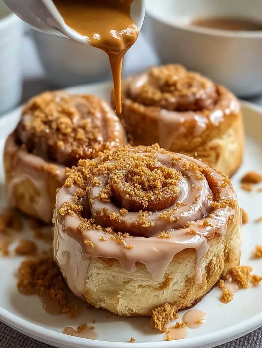 A delicious cinnamon roll with icing drizzled on top.