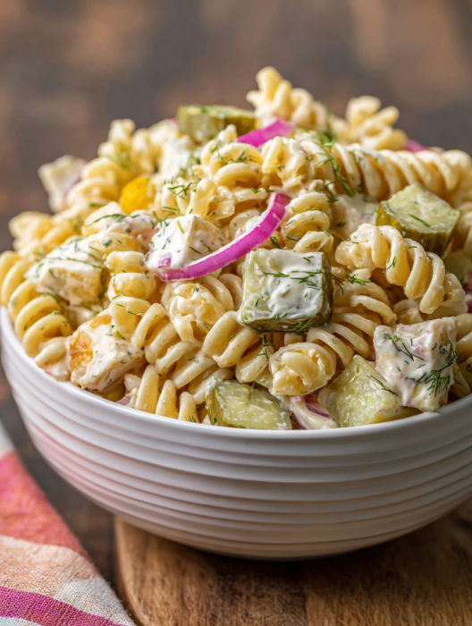 A bowl of pasta salad with dill pickles and cream cheese.