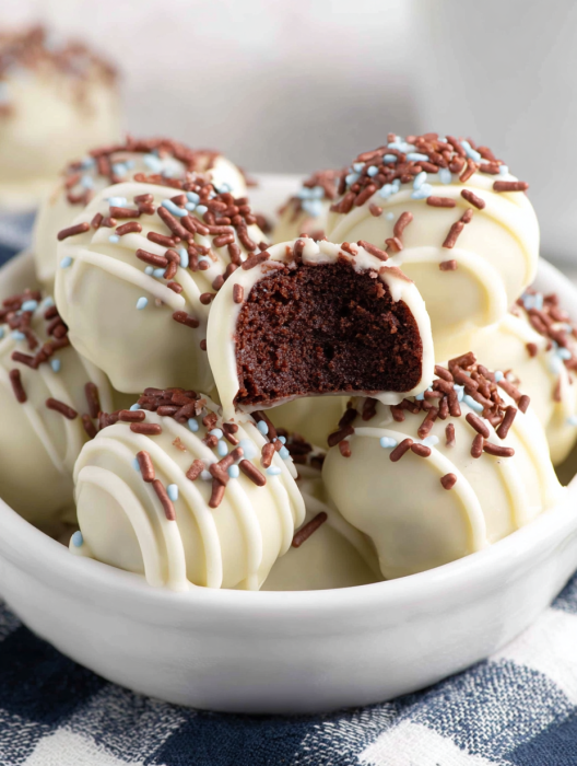 A bowl of chocolate and white cake balls.