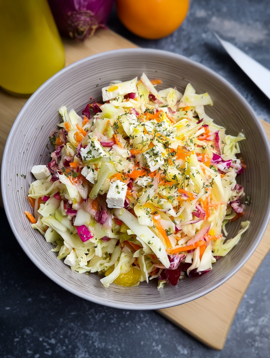 A bowl of salad with carrots and other vegetables.