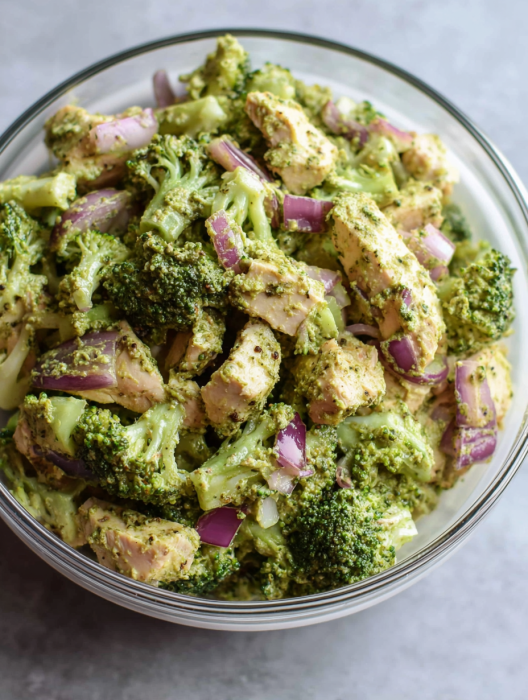 A bowl of food with broccoli and onions.