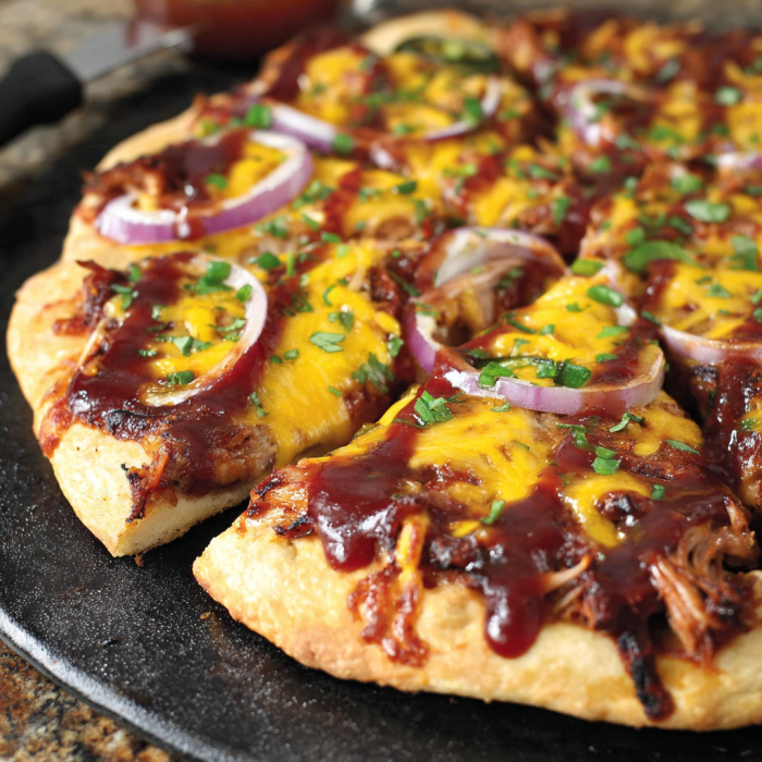 A slice of Texas BBQ pizza with onions and cheese.