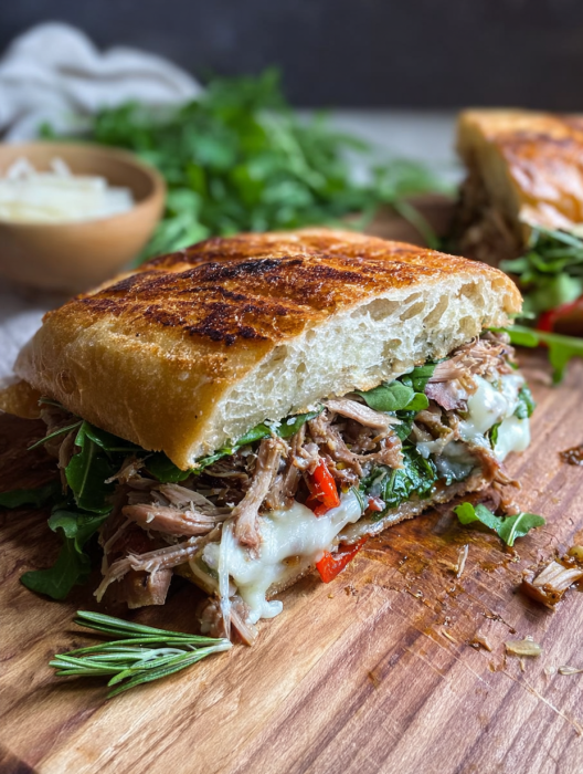 A sandwich with meat and cheese on a wooden table.