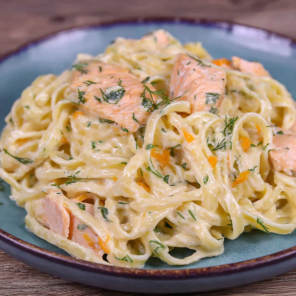 A plate of pasta with salmon and herbs.