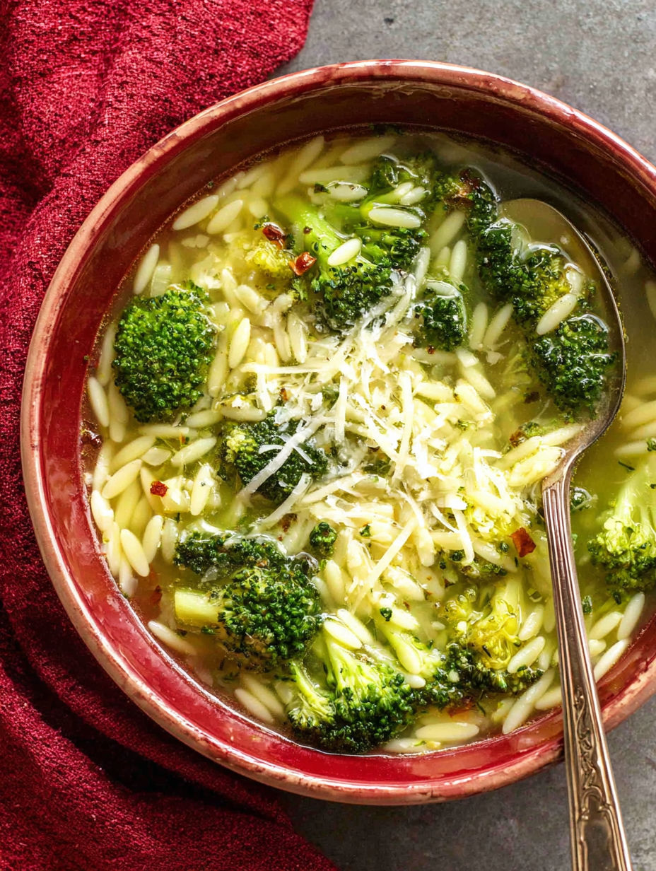 A bowl of soup with broccoli and pasta.