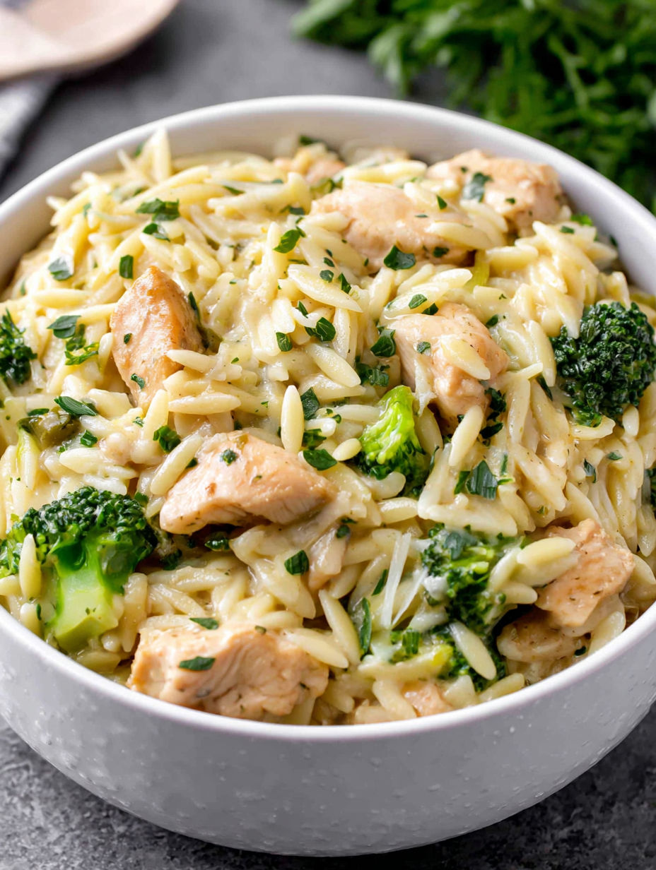 A bowl of pasta with chicken and broccoli.