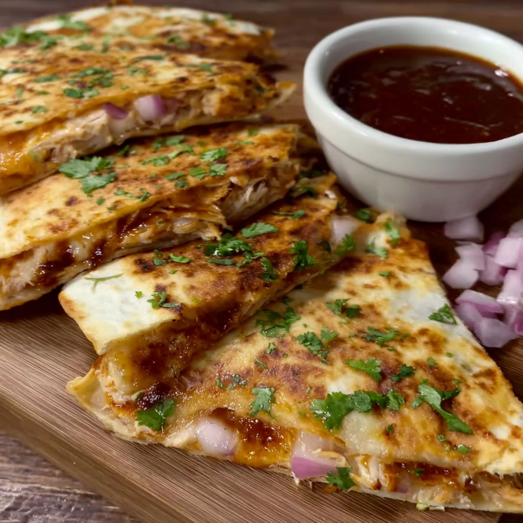 A white bowl of sauce sits next to a plate of food.