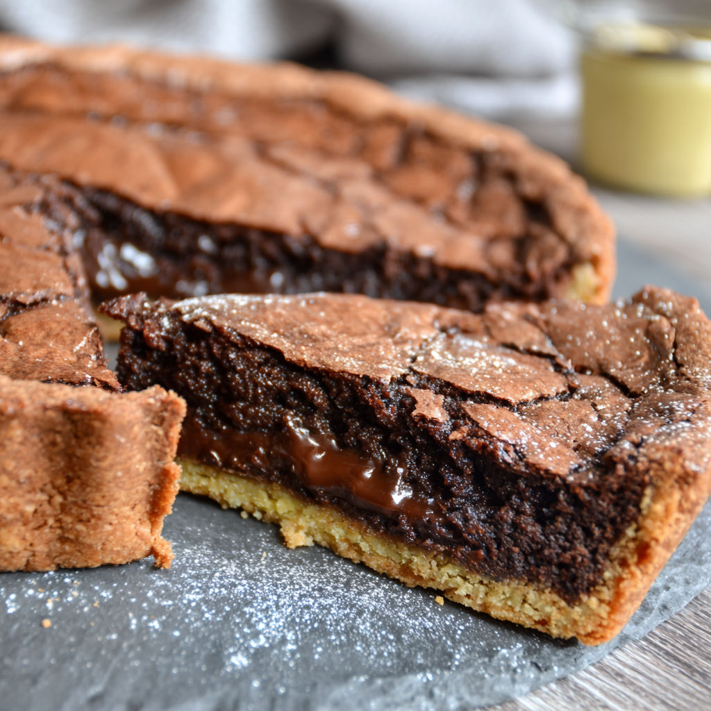 A slice of chocolate brownie with chocolate drizzle.