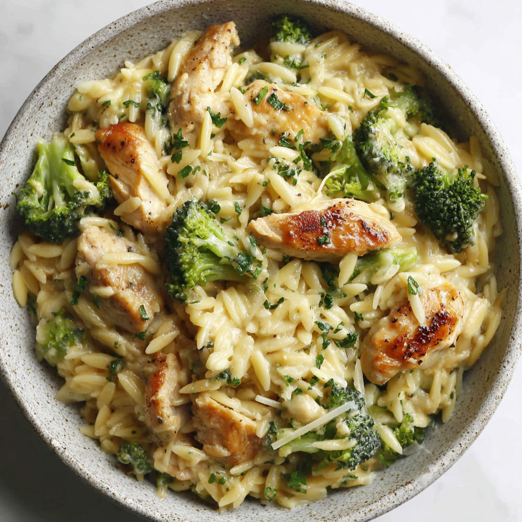 A bowl of cheesy chicken broccoli orzo.