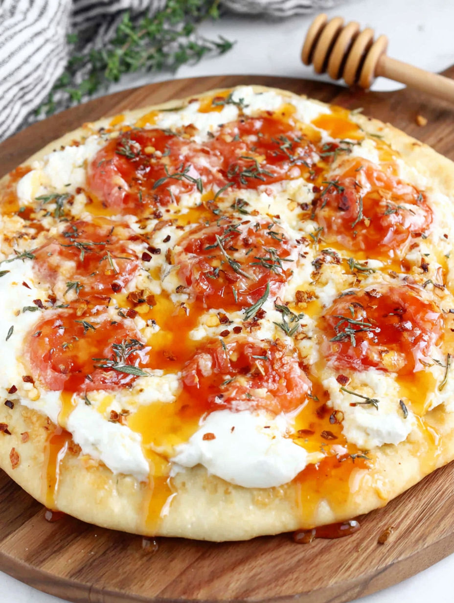 A pizza with tomatoes and cheese on a wooden board.