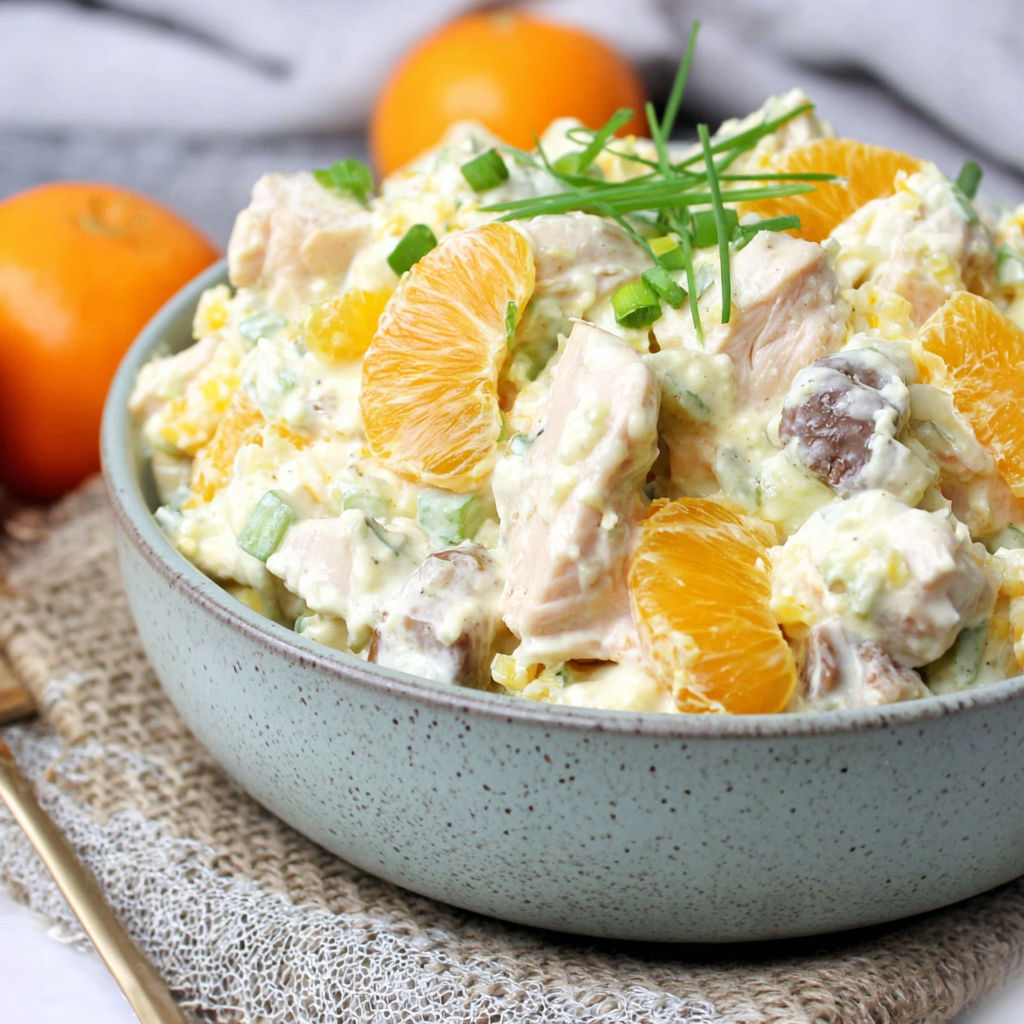 A bowl of food with oranges and other ingredients.