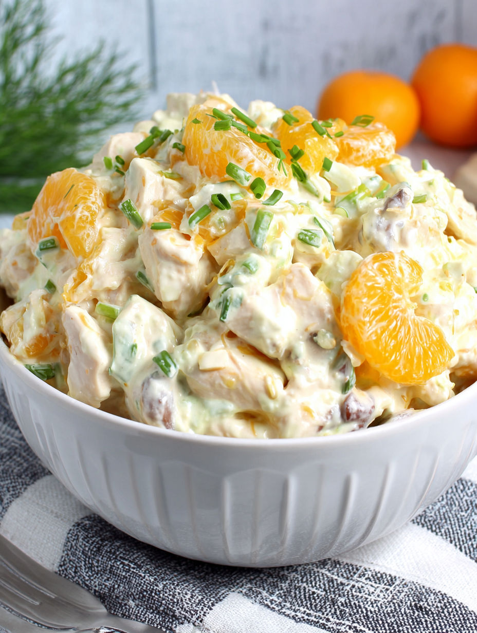 A white bowl filled with a salad containing oranges and green onions.