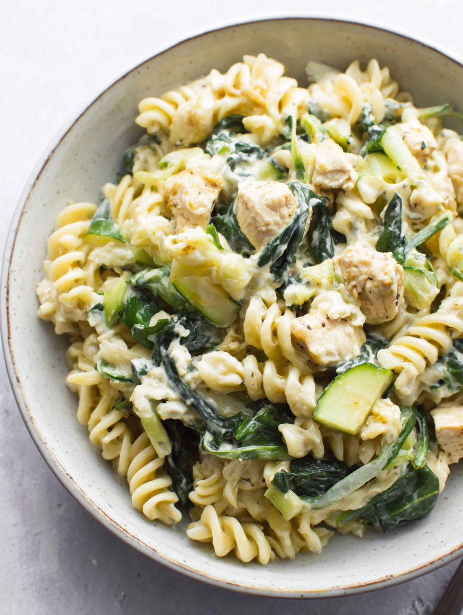 A bowl of pasta with chicken and vegetables.