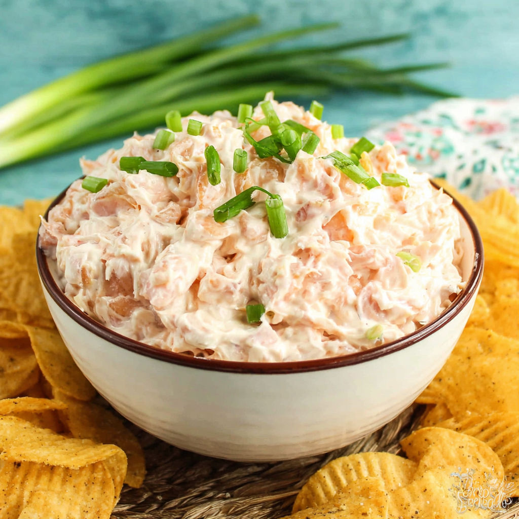 A bowl of shrimp dip with a green garnish.