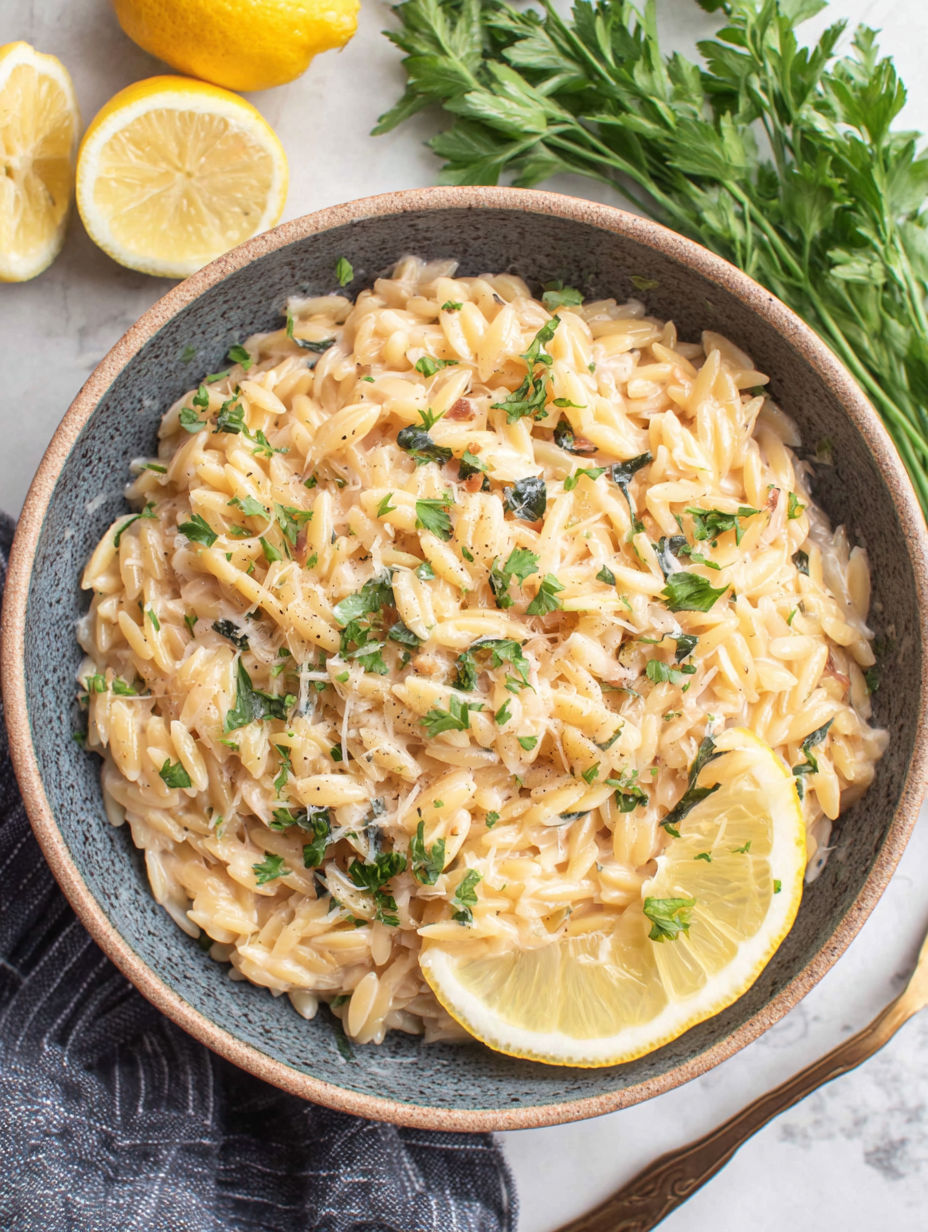 A bowl of pasta with lemon wedges on top.