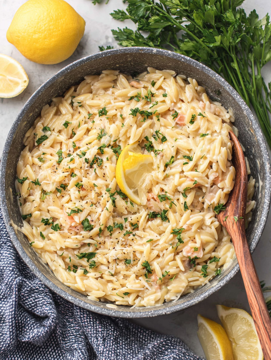 A bowl of pasta with lemon slices on top.