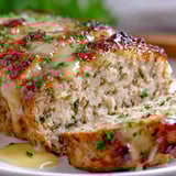 Eine Scheibe von Garlic Parmesan Chicken Meatloaf auf einem Teller.