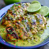 Ein Plate mit grilled Salsa Verde Pepper Jack Chicken, garniert mit Lime.