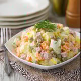 A white plate with a salad on it.