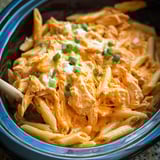 A crockpot filled with chicken and sauce.