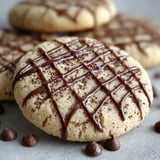 A close up of a chocolate drizzled cookie.