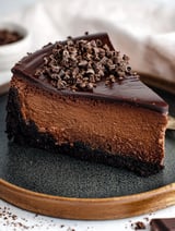 A slice of chocolate cheesecake with chocolate chips on top.