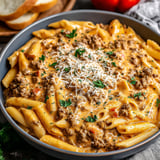 A bowl of pasta with meat and cheese.