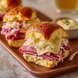 A plate of Reuben sandwiches with sauce.