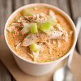 A bowl of soup with chicken and vegetables.