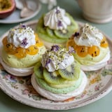 Three mini pavlovas with kiwi custard and matcha whipped cream.
