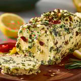 A large piece of cowboy butter with herbs on top.