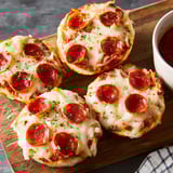Two slices of pizza on a wooden cutting board.