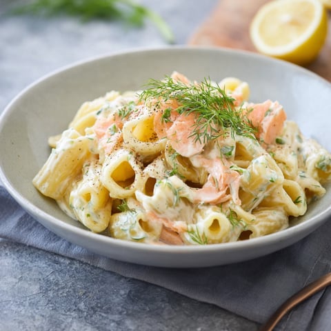 A bowl of pasta with cheese sauce and smoked salmon.