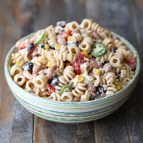 A bowl of pasta salad with corn, tomatoes, and black beans.