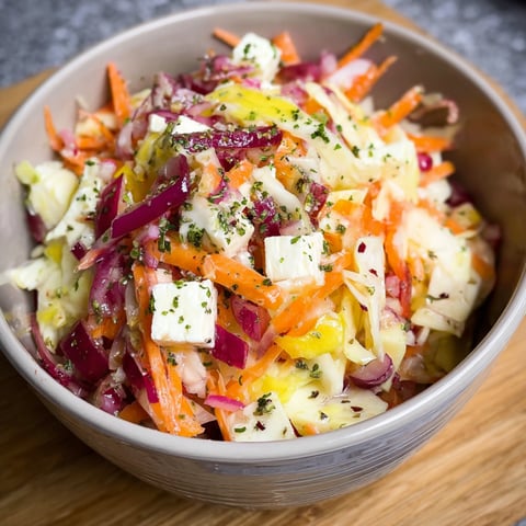 A bowl of vegetables with a white substance on top.
