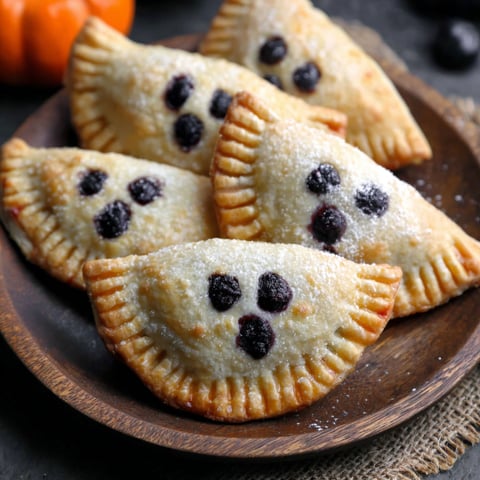 Blueberry ghost hand pies on a plate.