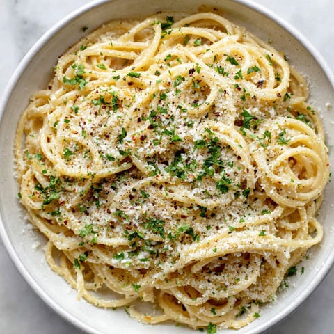 A bowl of pasta with garlic and Parmesan cheese.