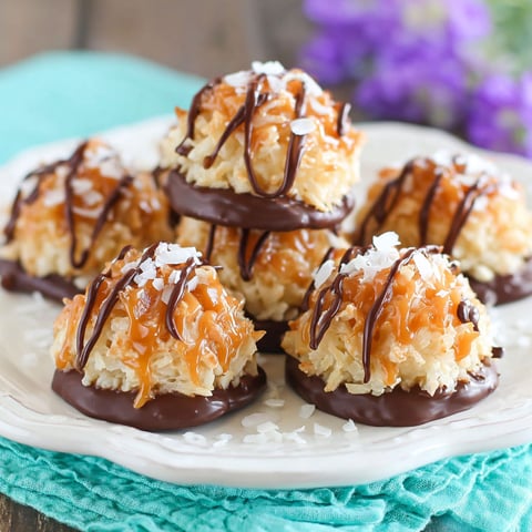 A plate of coconut macaroons with chocolate drizzle.