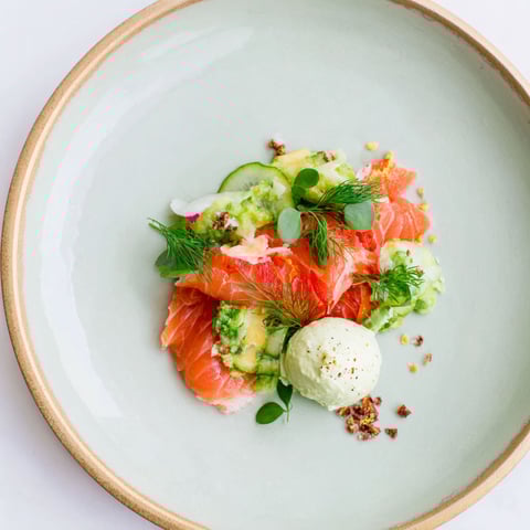 A plate of food with a salad and fish.