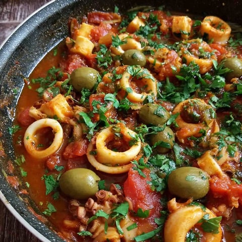 A spicy calamari stew with olives and tomatoes.