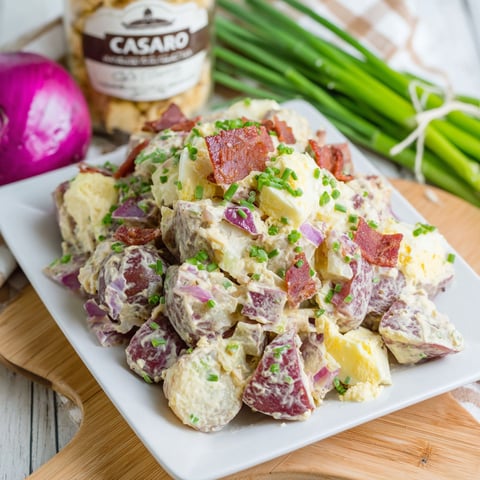 A white plate with a dish of potato salad.