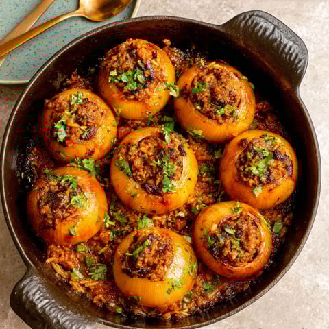A bowl of stuffed onions with a spoon.